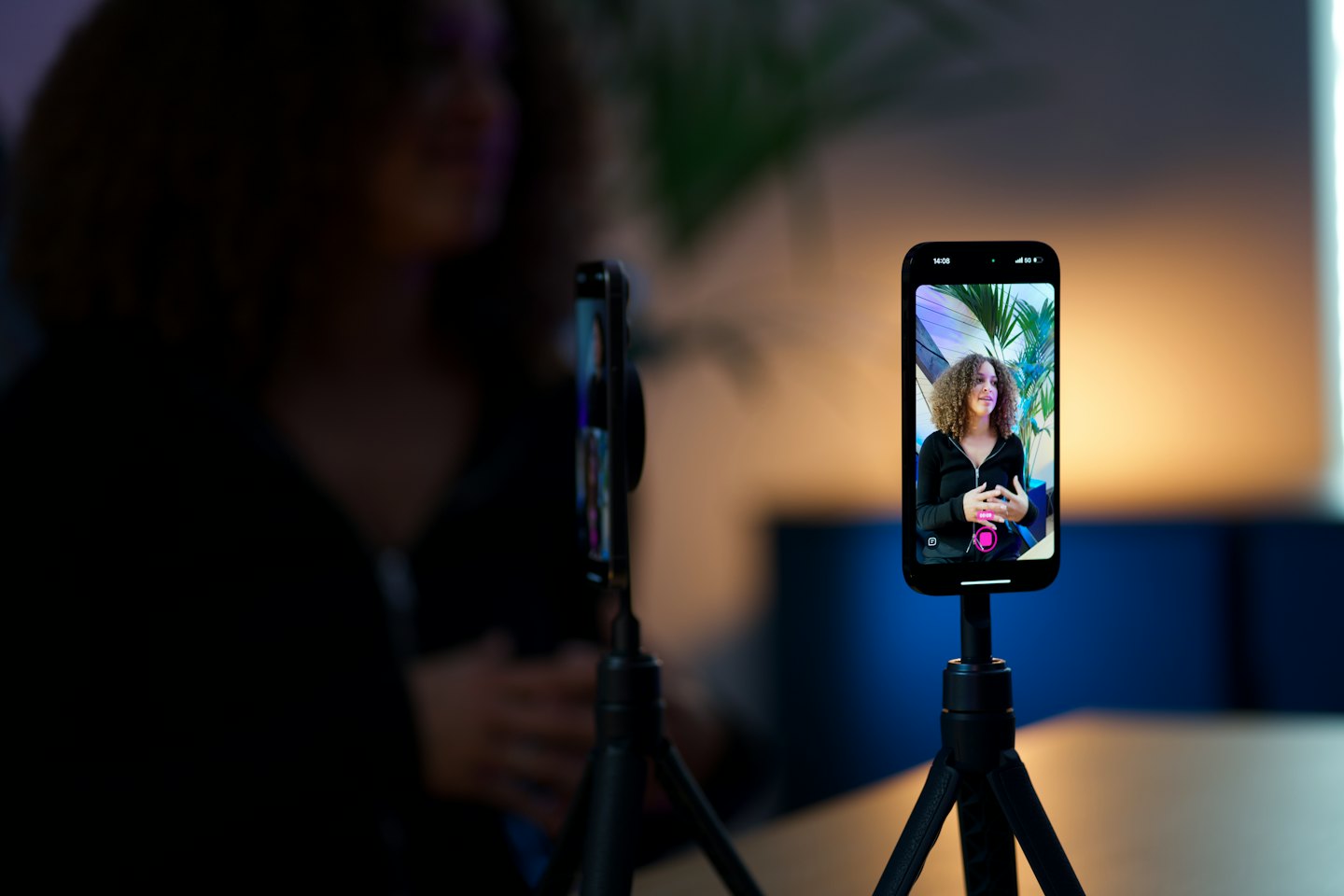 Smartphone on a tripod recording a woman presenting for video.